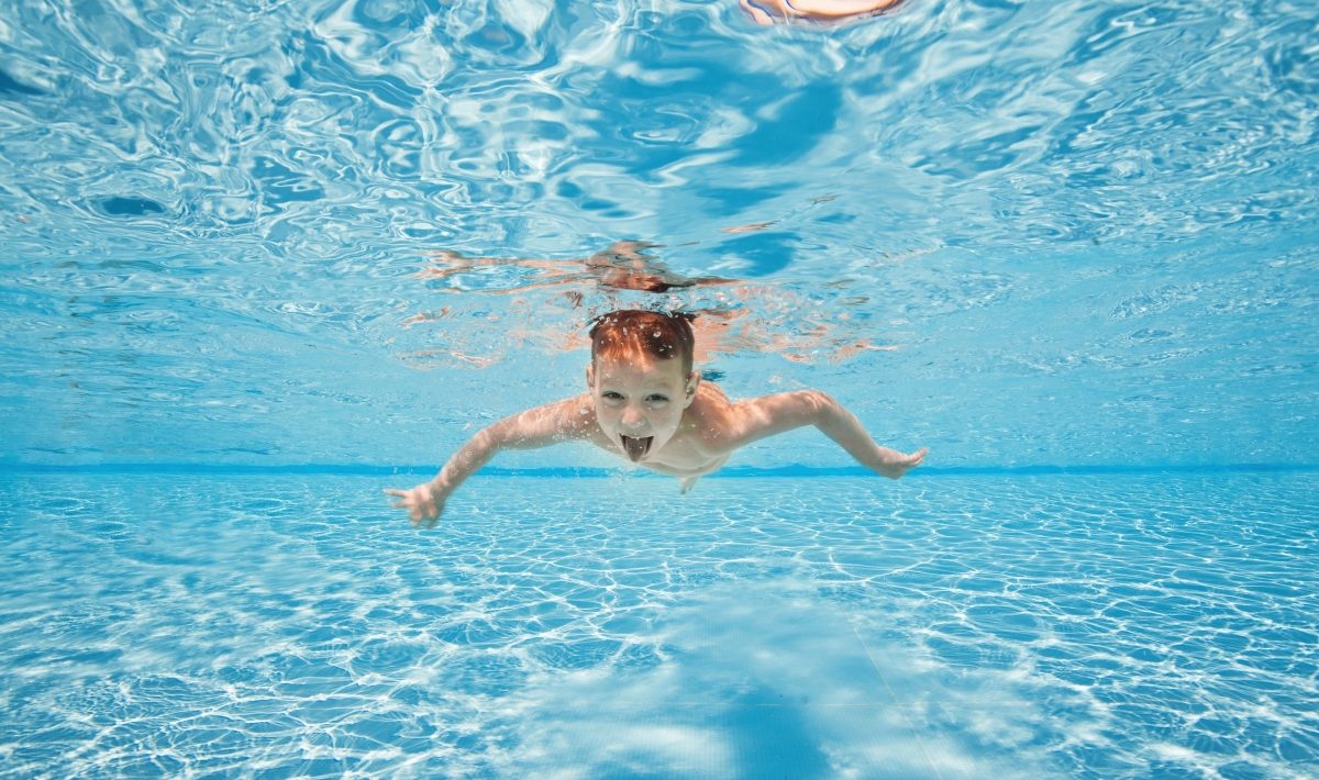un enfant plongeant dans une piscine